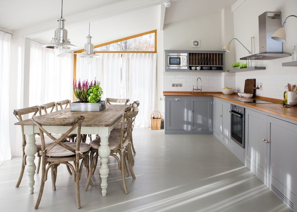 Белые стены в кухне-гостиной с деревянным столом