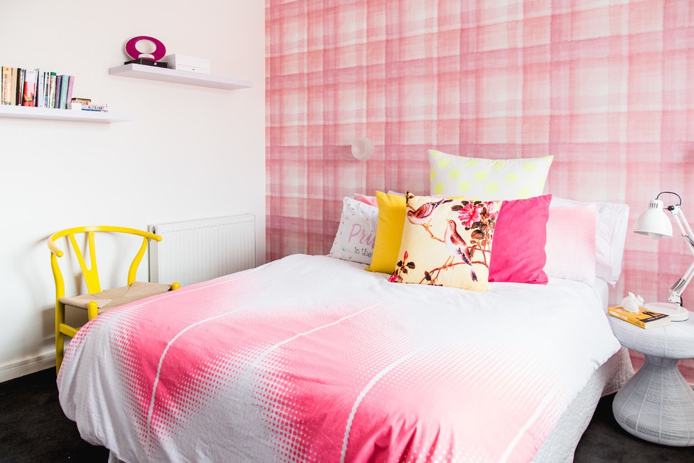 Желтый стул возле кровати с бело-розовым покрывалом