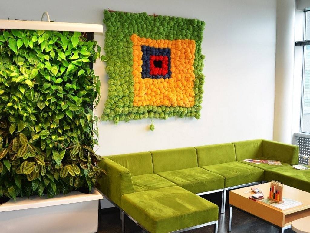 Живая стена в комнате с зеленым диваном