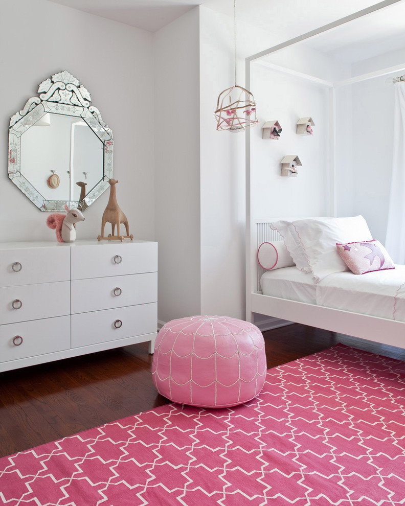 Розовый ковер в комнате с белым комодом