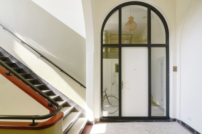 Интерьер двухуровневой квартиры: вход в квартиру за стеклом