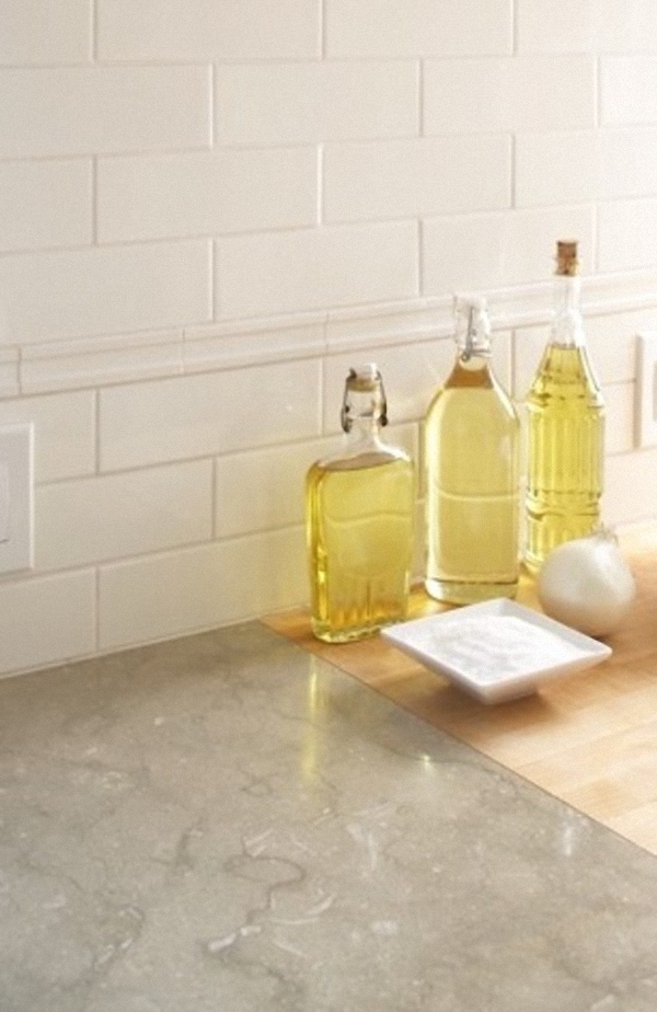 Бутылочки разной формы для хранения масла на мраморной столешнице кухни