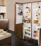 Широкий холодильник за дверьми шкафа