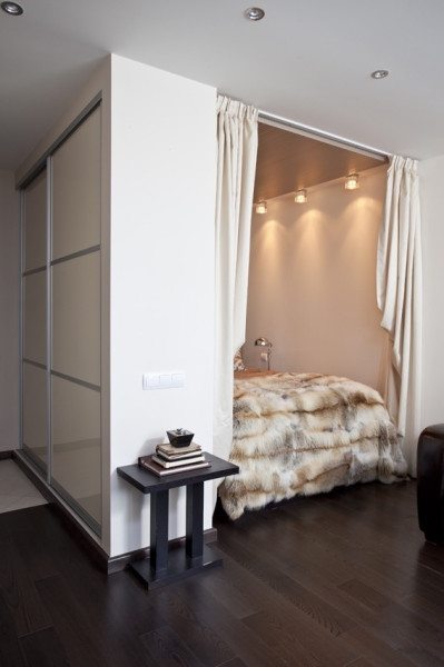 Фото комнаты в стиле минимализм, где спальное место отгорожено от гостиной с помощью ниши с плотными занавесями.