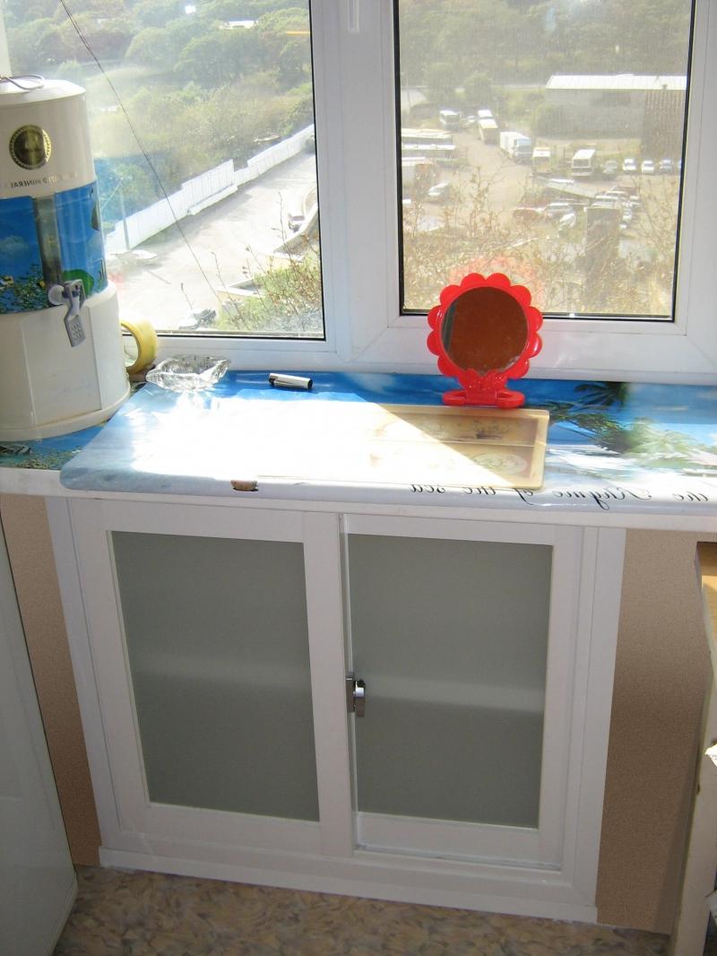 Холодильник под окном со стеклянными дверками