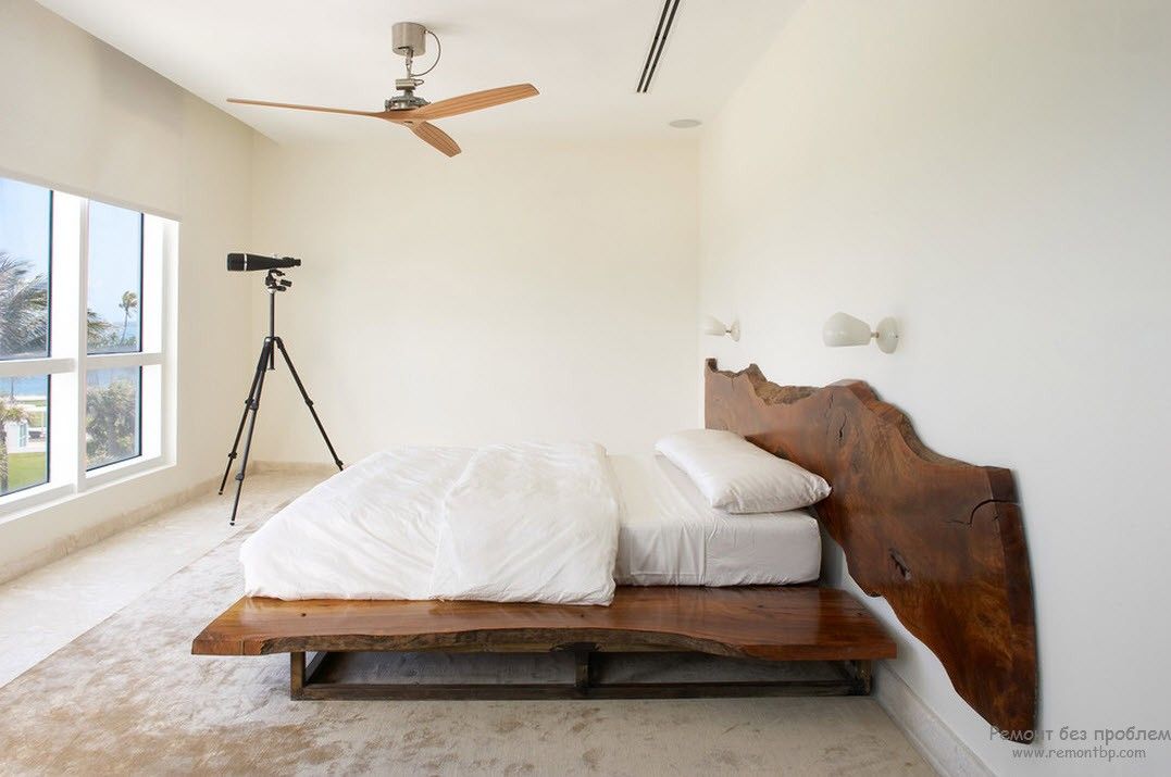 Светлый интерьер спальни с контрастной темной деревянной кроватью
